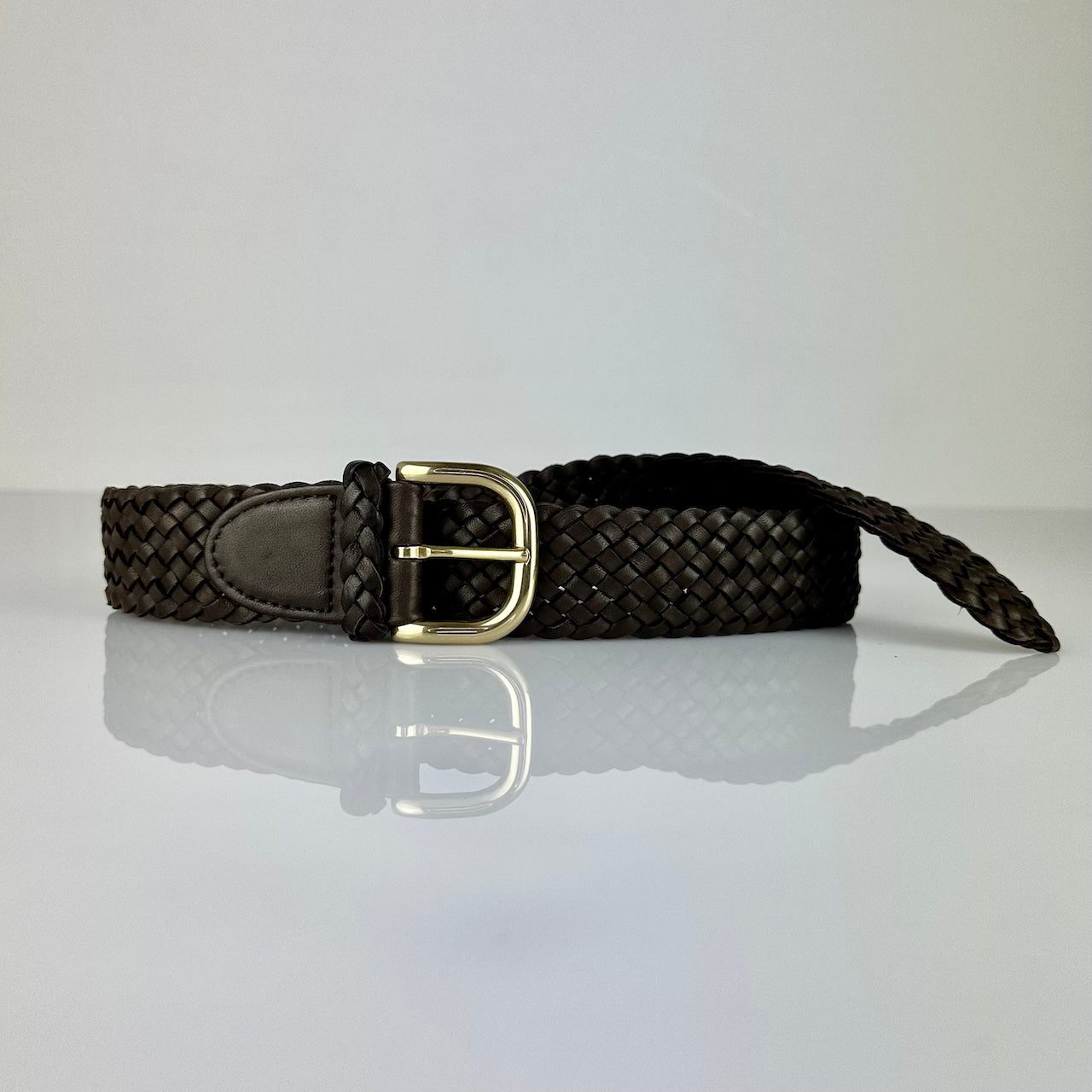 Der Braided Belt 40 in Darkbrown von LABEL17 ist ein Gürtel gefertigt aus geschmeidigem, pflanzlich gegerbtem Lamm-Nappaleder, von Hand geflochten in der Farbe dunkelbraun. Mit Messingschnalle.