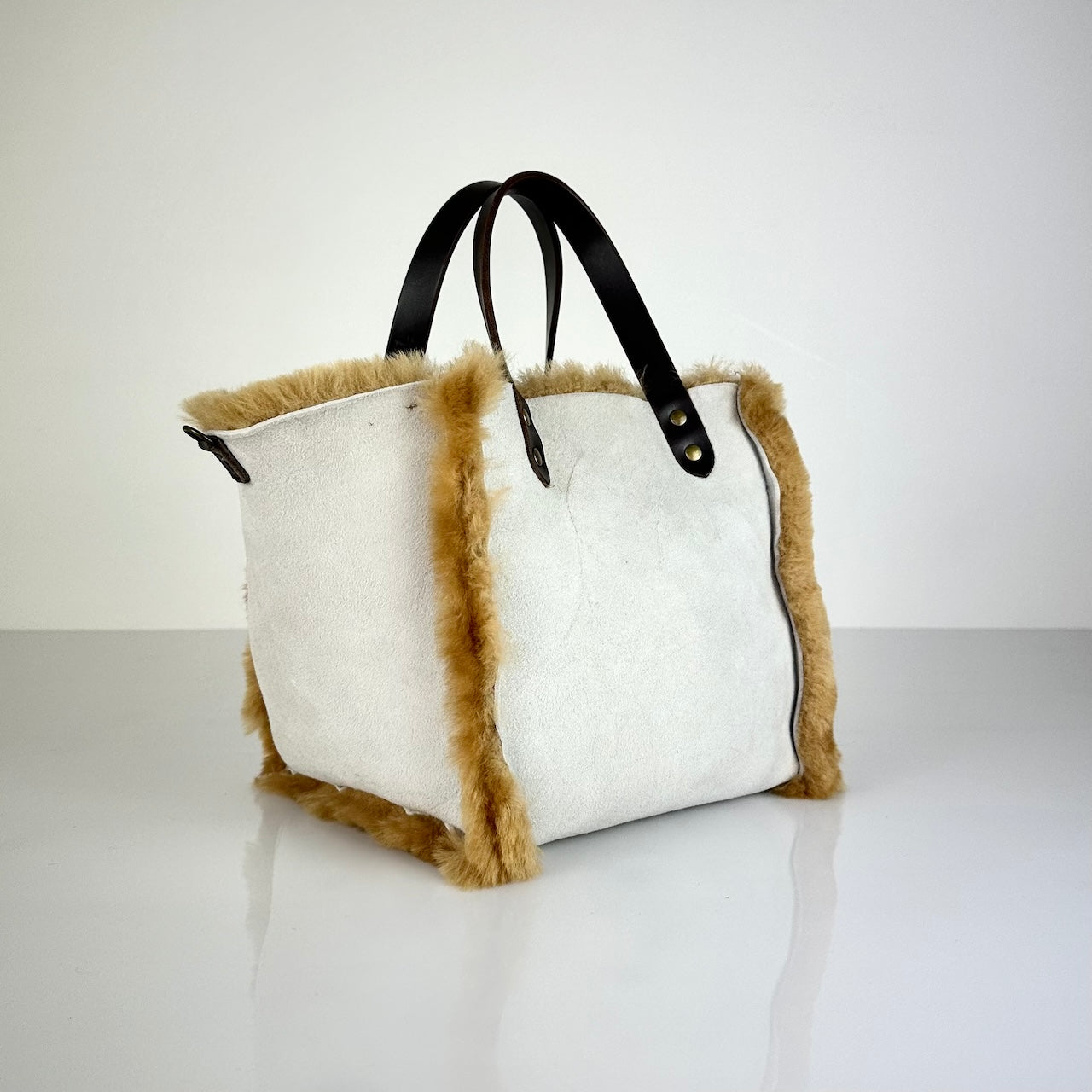 Diese HANDBAG SHEARLING REVERSIBLE, MEDIUM von LABEL17 wird aus luxuriösem Merino-Lammfell gefertigt, das der Tasche einen einzigartigen und stilvollen Look verleiht. Mit dunkelbraunen Griffen aus Sattlerleder und einem abnehmbaren Schulterriemen bietet sie vielseitige Tragemöglichkeiten, egal ob in der Hand oder als Crossbody.
Diese reversible Tasche ist ein Meisterwerk der Schweizer Handwerkskunst und vereint schlichtes Design mit hochwertiger Sattlerarbeit. Jede Tasche ist ein Unikat.