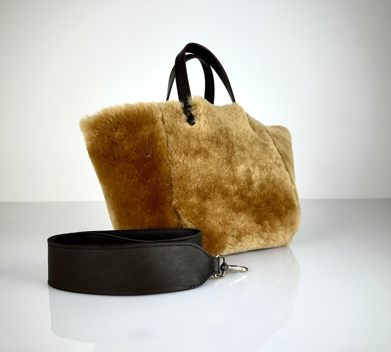 Diese HANDBAG SHEARLING REVERSIBLE, MEDIUM von LABEL17 wird aus luxuriösem Merino-Lammfell gefertigt, das der Tasche einen einzigartigen und stilvollen Look verleiht. Mit dunkelbraunen Griffen aus Sattlerleder und einem abnehmbaren Schulterriemen bietet sie vielseitige Tragemöglichkeiten, egal ob in der Hand oder als Crossbody.
Diese reversible Tasche ist ein Meisterwerk der Schweizer Handwerkskunst und vereint schlichtes Design mit hochwertiger Sattlerarbeit. Jede Tasche ist ein Unikat.