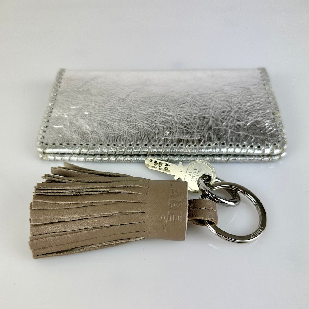 Der Keyring Pompom Medium in Grey von LABEL17 ist ein Mittelgrosser Schlüsselanhänger, gefertigt aus geschmeidigem, pflanzlich gegerbtem Lamm-Nappaleder. Liegt angenehm in der Hand und ziert jeden Schlüsselbund.