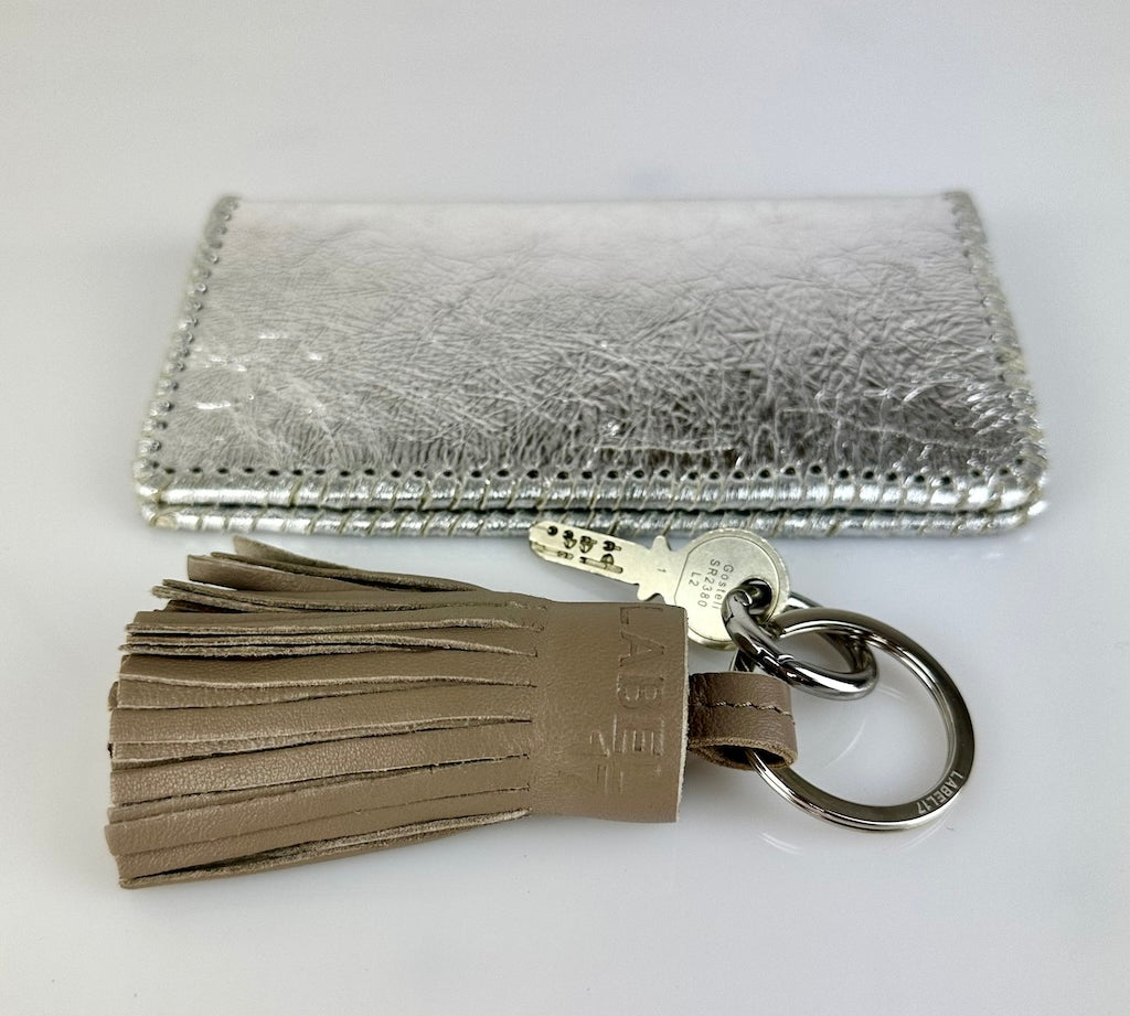 Der Keyring Pompom Medium in Grey von LABEL17 ist ein Mittelgrosser Schlüsselanhänger, gefertigt aus geschmeidigem, pflanzlich gegerbtem Lamm-Nappaleder. Liegt angenehm in der Hand und ziert jeden Schlüsselbund.