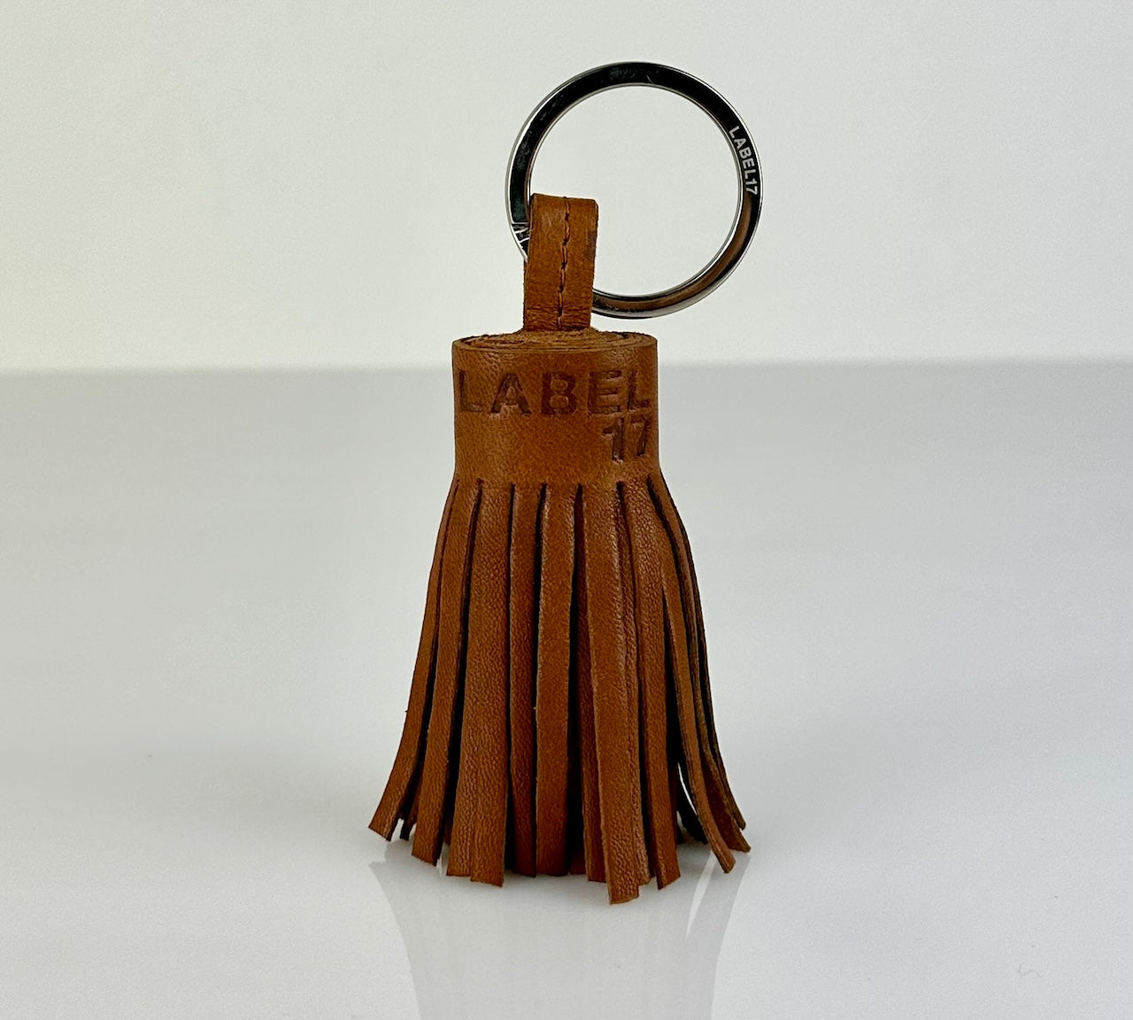 Der Keyring Pompom Medium in Cognac von LABEL17 ist ein Mittelgrosser Schlüsselanhänger, gefertigt aus geschmeidigem, pflanzlich gegerbtem Lamm-Nappaleder. Liegt angenehm in der Hand und ziert jeden Schlüsselbund.