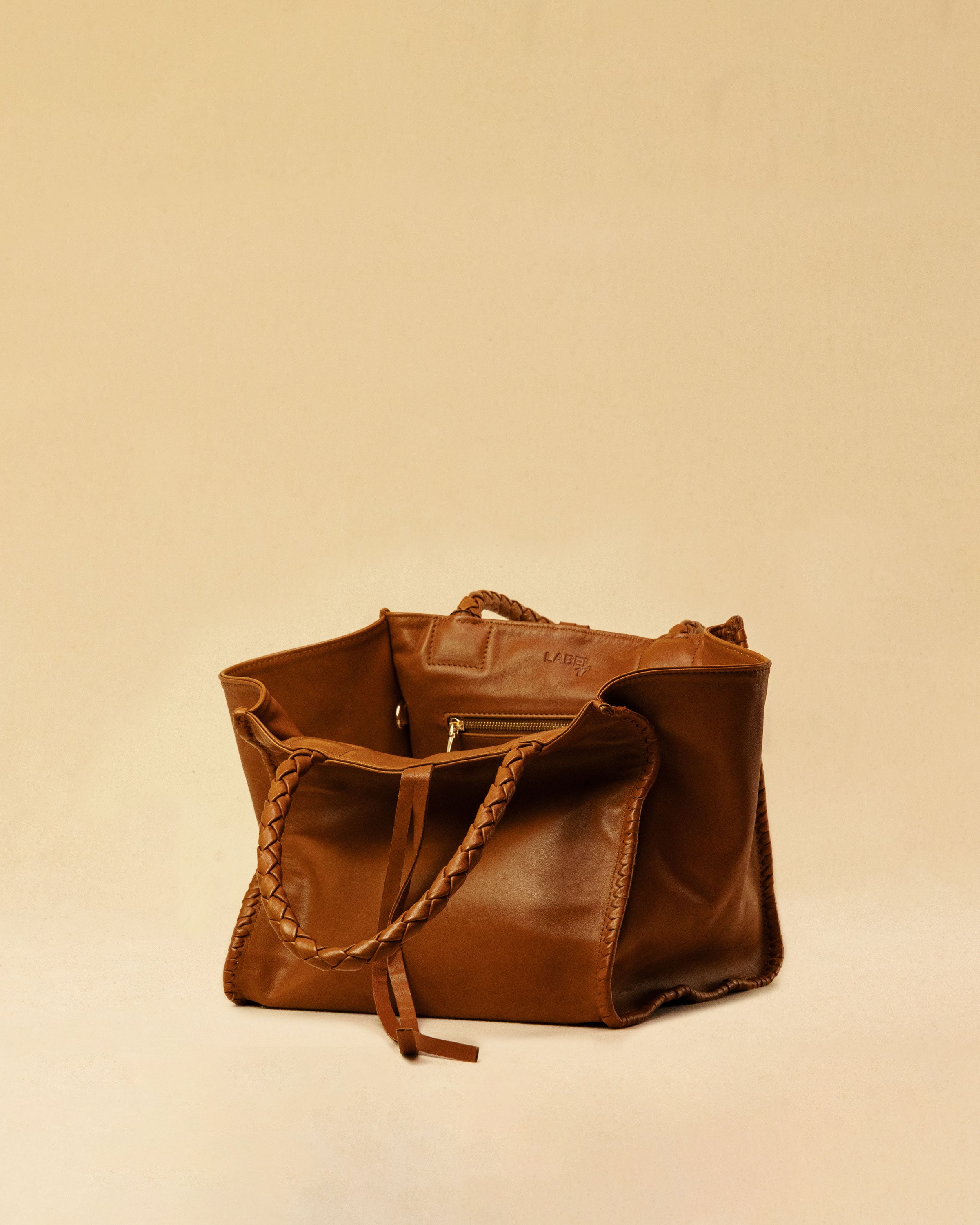 The Shoulder Bag IVY, crafted from supple, vegetable-tanned nappa leather, stands out for its artisanal detailing, distinctive side seams, and long braided handles. The interior lining and zippered side pocket are also made of fine nappa leather.