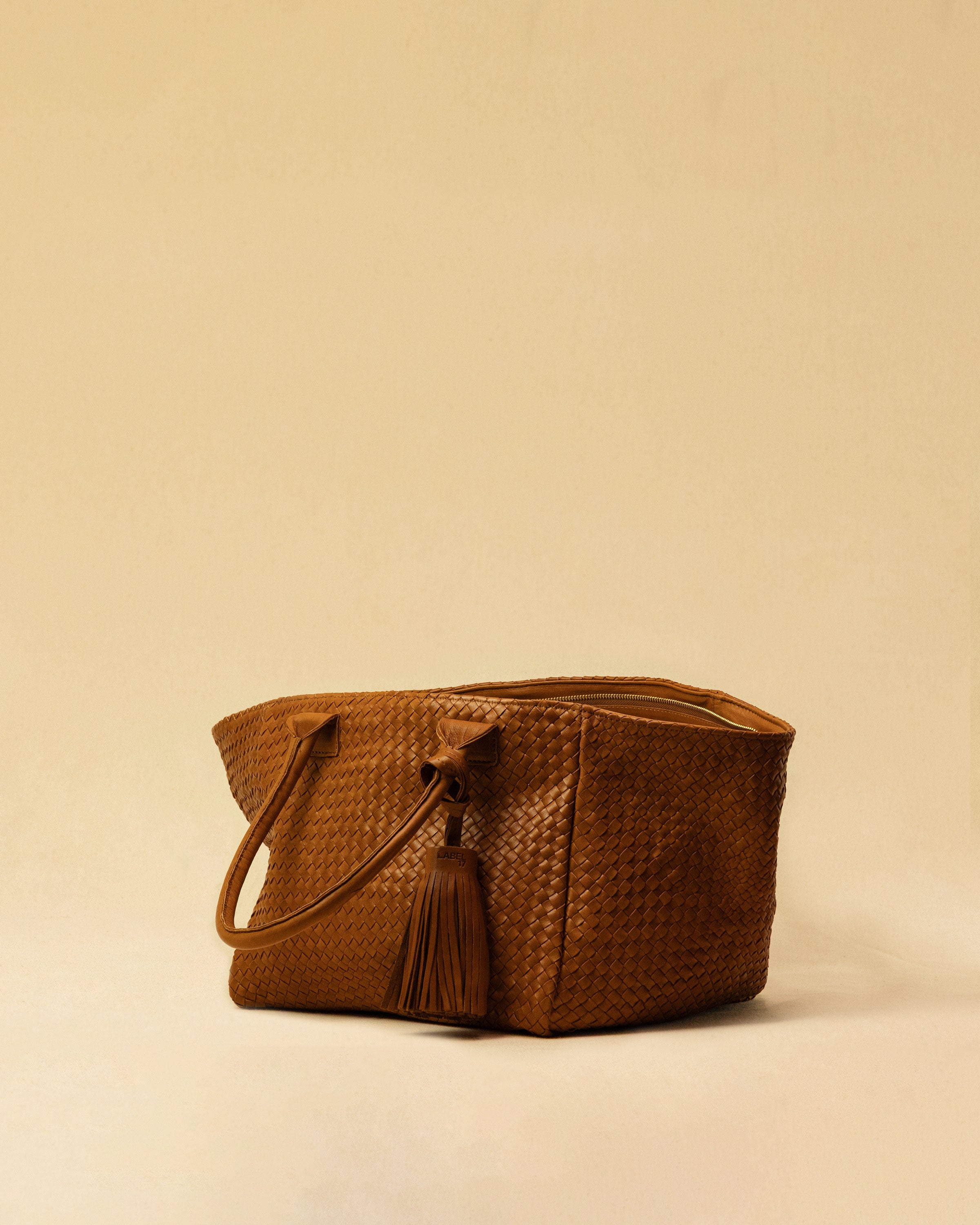 The Shoulder Bag Original by LABEL17 is a timeless piece, crafted from fine, vegetable-tanned nappa leather and hand-braided. It features a zipper closure and a convenient interior pocket for your essentials. A large leather pompom, used here as a decorative charm, ist attached to the handle and can be removed.