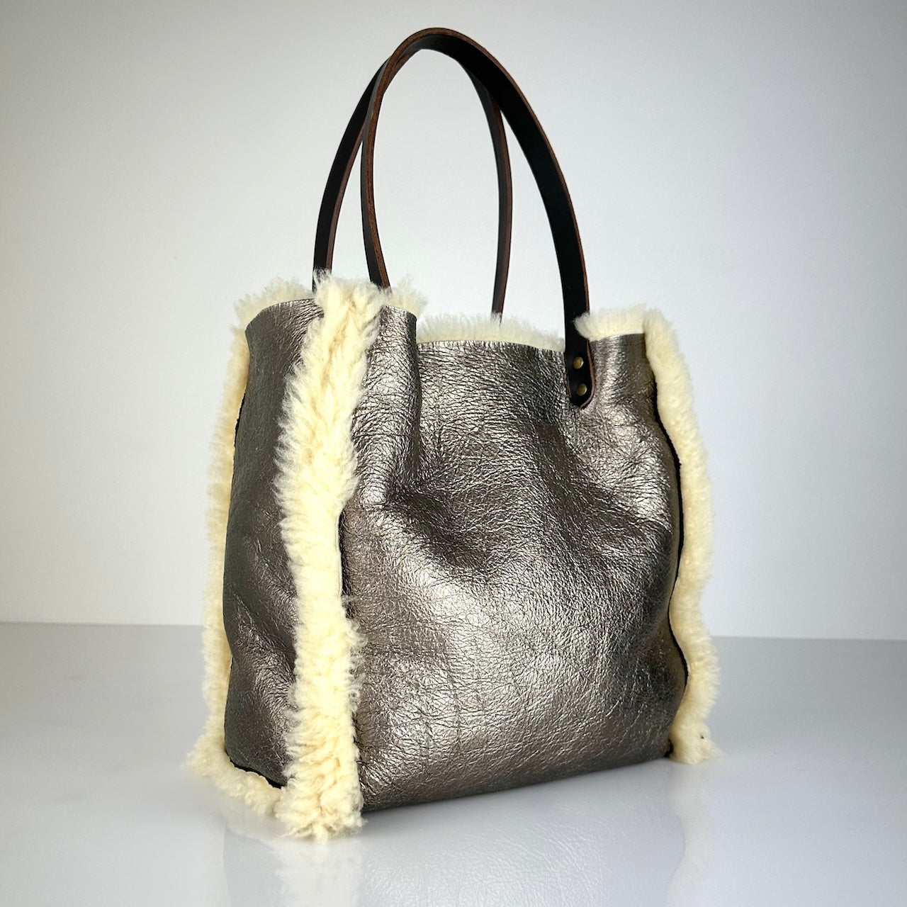 Die Shoulder Bag Reversible Snow von LABEL17 wird aus luxuriösem Merino-Lammfell gefertigt. Mit langen dunkelbraunen Schulterriemen aus Sattlerleder kann die Tasche über die Schulter getragen werden.
Diese reversible Tasche ist ein Meisterwerk der Schweizer Handwerkskunst und vereint schlichtes Design mit hochwertiger Sattlerarbeit. Jede Tasche ist ein Unikat.