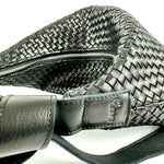 The LABEL17 Shoulder Bag Saddle Tresse is braided by hand and crafted from the most supple Nappa leather exemplifying luxury and durability. Designed with a unique saddle shape, it conforms seamlessly to your body. The bag is lined with leather and has practical compartments, including a zippered compartment for safe storage. Featuring a zipper and an adjustable shoulder strap, this versatile accessory offers the freedom to be worn over the shoulder or across the body.