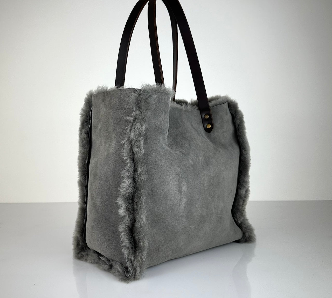 Die Shoulder Bag Reversible Snow von LABEL17 wird aus luxuriösem Merino-Lammfell gefertigt. Mit langen dunkelbraunen Schulterriemen aus Sattlerleder kann die Tasche über die Schulter getragen werden.
Diese reversible Tasche ist ein Meisterwerk der Schweizer Handwerkskunst und vereint schlichtes Design mit hochwertiger Sattlerarbeit. Jede Tasche ist ein Unikat.