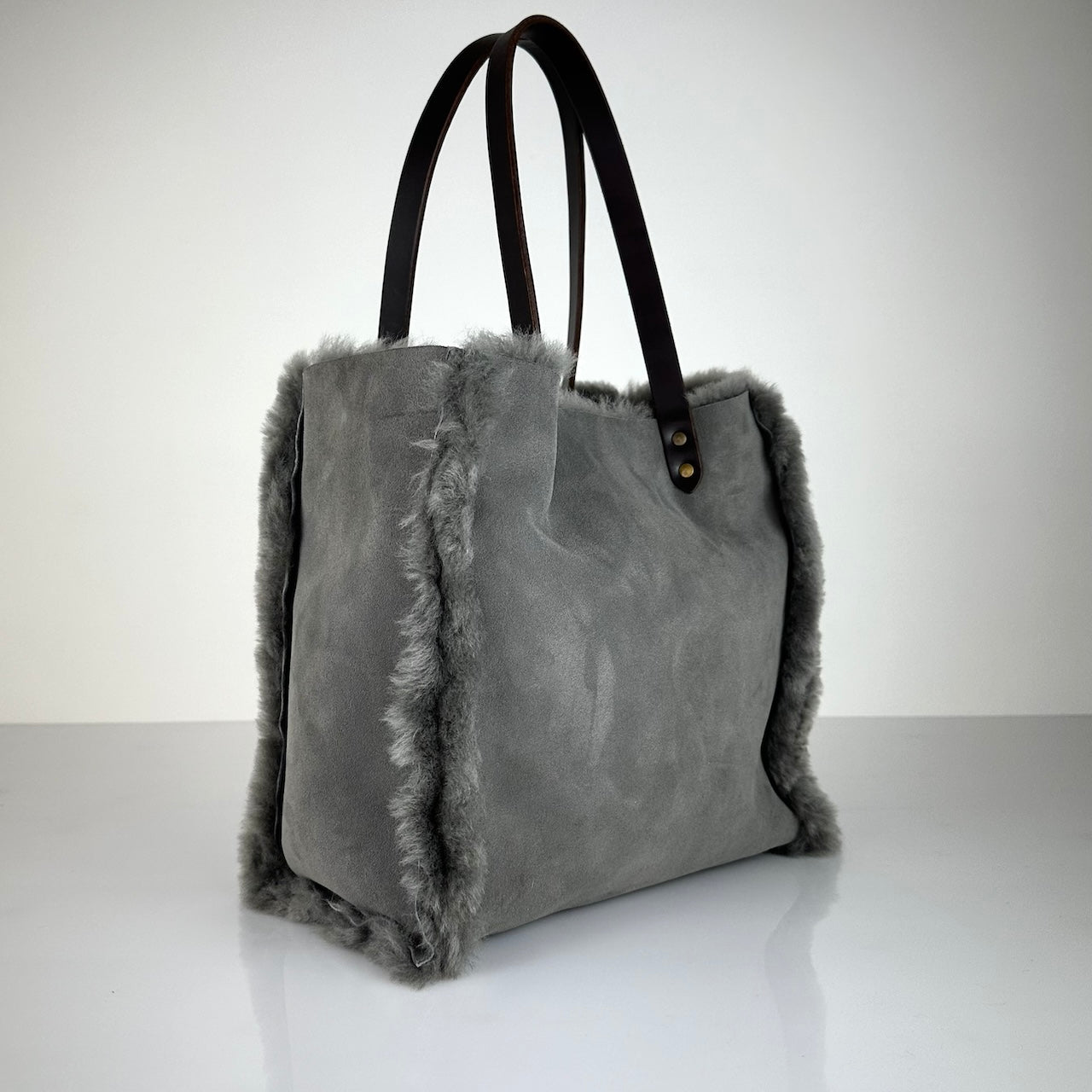 Die Shoulder Bag Reversible Snow von LABEL17 wird aus luxuriösem Merino-Lammfell gefertigt. Mit langen dunkelbraunen Schulterriemen aus Sattlerleder kann die Tasche über die Schulter getragen werden.
Diese reversible Tasche ist ein Meisterwerk der Schweizer Handwerkskunst und vereint schlichtes Design mit hochwertiger Sattlerarbeit. Jede Tasche ist ein Unikat.