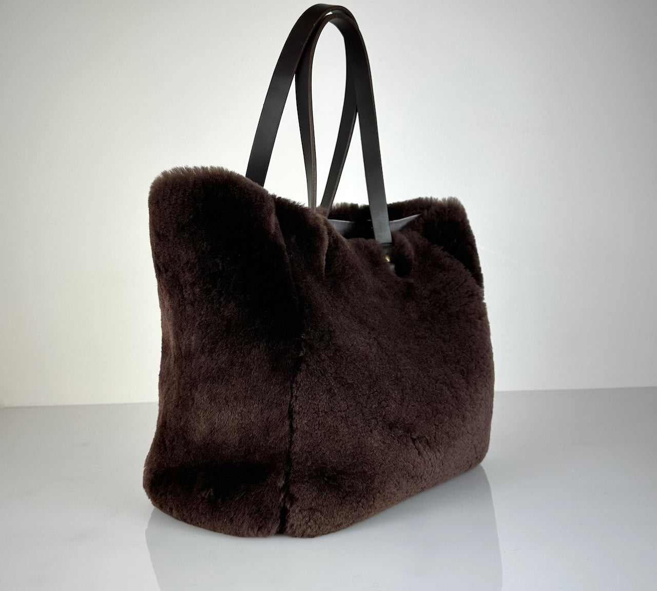 Die Shoulder Bag Reversible Snow von LABEL17 wird aus luxuriösem Merino-Lammfell gefertigt. Mit langen dunkelbraunen Schulterriemen aus Sattlerleder kann die Tasche über die Schulter getragen werden.
Diese reversible Tasche ist ein Meisterwerk der Schweizer Handwerkskunst und vereint schlichtes Design mit hochwertiger Sattlerarbeit. Jede Tasche ist ein Unikat.