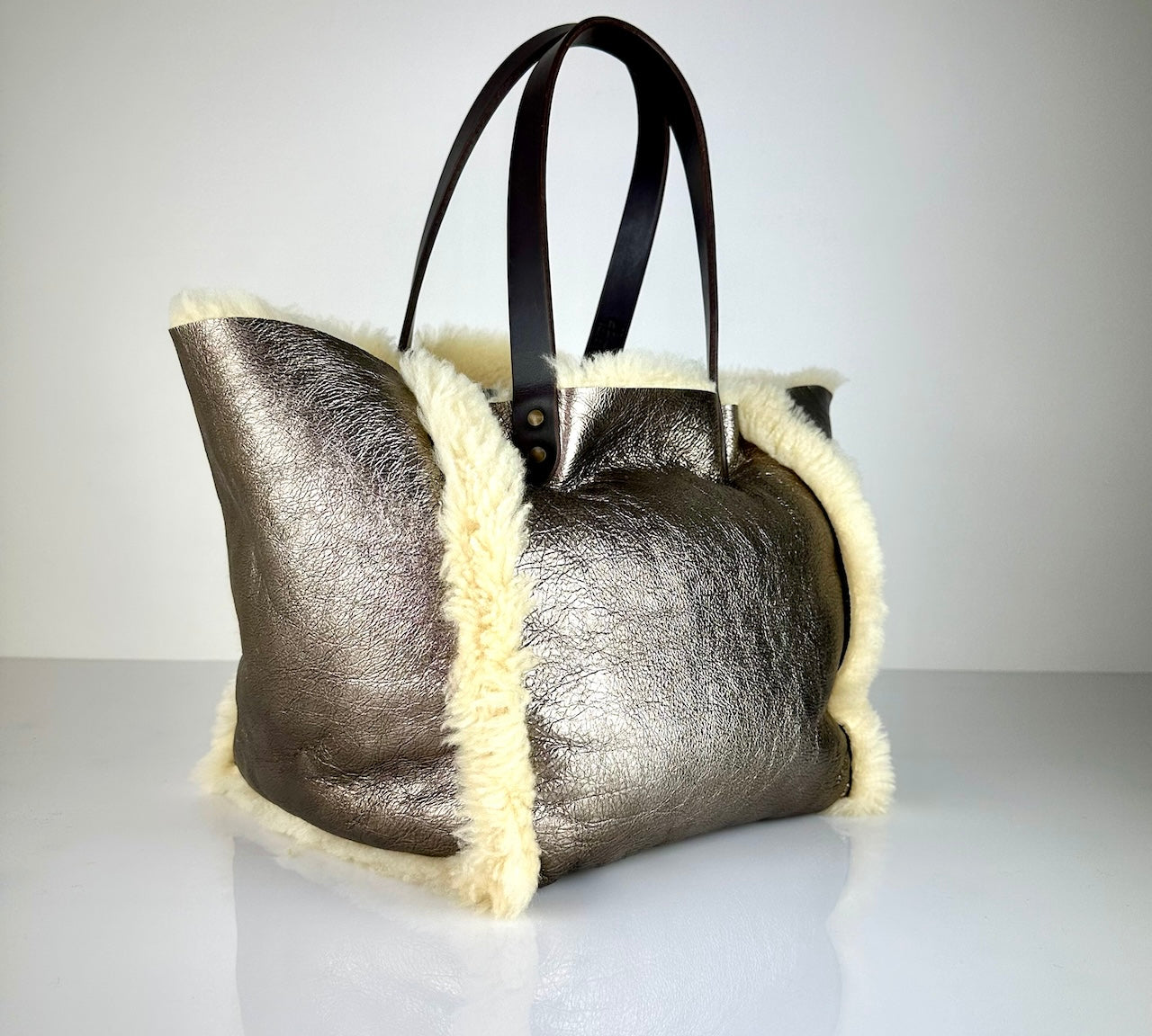 Die SHOULDER BAG SHEARLING REVERSIBLE von LABEL17 wird aus luxuriösem Merino-Lammfell gefertigt, das der Tasche einen einzigartigen und stilvollen Look verleiht. Mit langen dunkelbraunen Schulterriemen aus Sattlerleder kann die Tasche bequem über die Schulter getragen werden.
Diese reversible Tasche ist ein Meisterwerk der Schweizer Handwerkskunst und vereint schlichtes Design mit hochwertiger Sattlerarbeit. Jede Tasche ist ein Unikat.