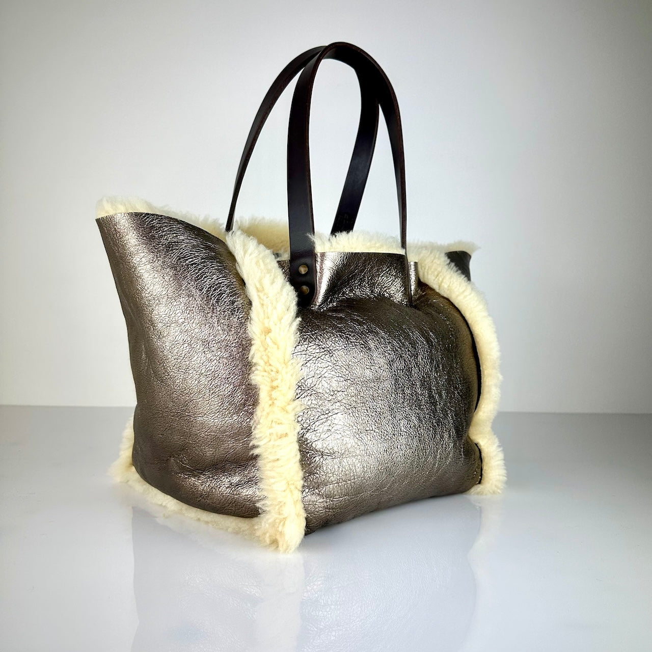 Die SHOULDER BAG SHEARLING REVERSIBLE von LABEL17 wird aus luxuriösem Merino-Lammfell gefertigt, das der Tasche einen einzigartigen und stilvollen Look verleiht. Mit langen dunkelbraunen Schulterriemen aus Sattlerleder kann die Tasche bequem über die Schulter getragen werden.
Diese reversible Tasche ist ein Meisterwerk der Schweizer Handwerkskunst und vereint schlichtes Design mit hochwertiger Sattlerarbeit. Jede Tasche ist ein Unikat.