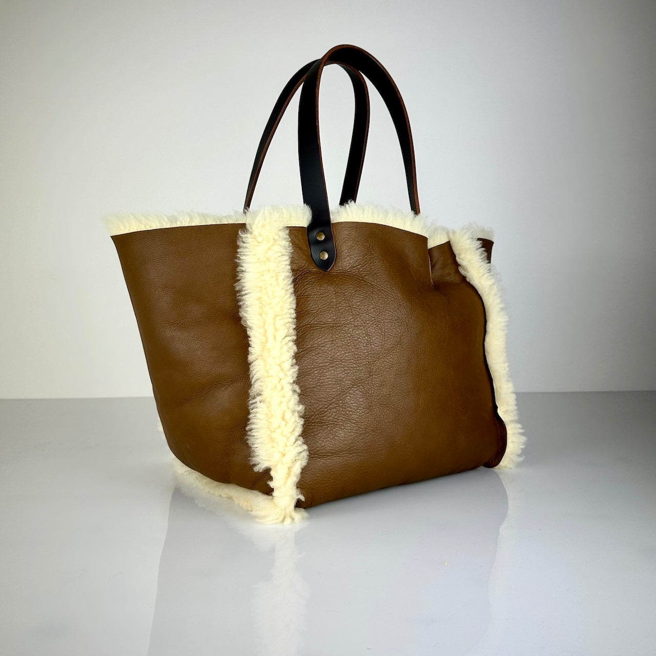 Die SHOULDER BAG SHEARLING REVERSIBLE von LABEL17 wird aus luxuriösem Merino-Lammfell gefertigt, das der Tasche einen einzigartigen und stilvollen Look verleiht. Mit langen dunkelbraunen Schulterriemen aus Sattlerleder kann die Tasche bequem über die Schulter getragen werden.
Diese reversible Tasche ist ein Meisterwerk der Schweizer Handwerkskunst und vereint schlichtes Design mit hochwertiger Sattlerarbeit. Jede Tasche ist ein Unikat.