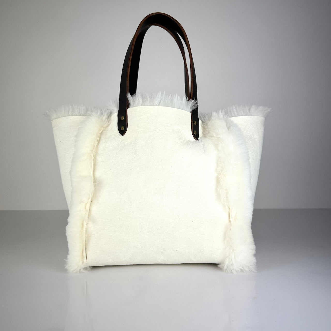 Die SHOULDER BAG SHEARLING REVERSIBLE von LABEL17 wird aus luxuriösem Merino-Lammfell gefertigt, das der Tasche einen einzigartigen und stilvollen Look verleiht. Mit langen dunkelbraunen Schulterriemen aus Sattlerleder kann die Tasche bequem über die Schulter getragen werden.
Diese reversible Tasche ist ein Meisterwerk der Schweizer Handwerkskunst und vereint schlichtes Design mit hochwertiger Sattlerarbeit. Jede Tasche ist ein Unikat.