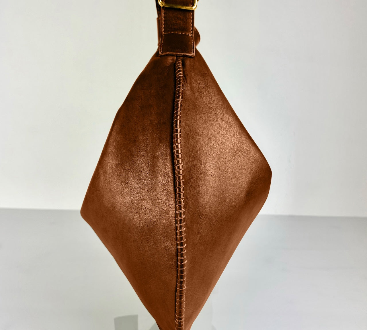 Shoulder Bag Saddle IVY in Caramel Brown: leichte und elegante Schulter- und Umhängetasche von LABEL17. Handgefertigt aus geschmeidigem, pflanzlich gegerbtem Lamm-Nappaleder mit Innenfutter aus Leder und inwendigen Innentaschen und Reissverschluss, tragbar als Handtasche, Schultertasche oder Crossbody.