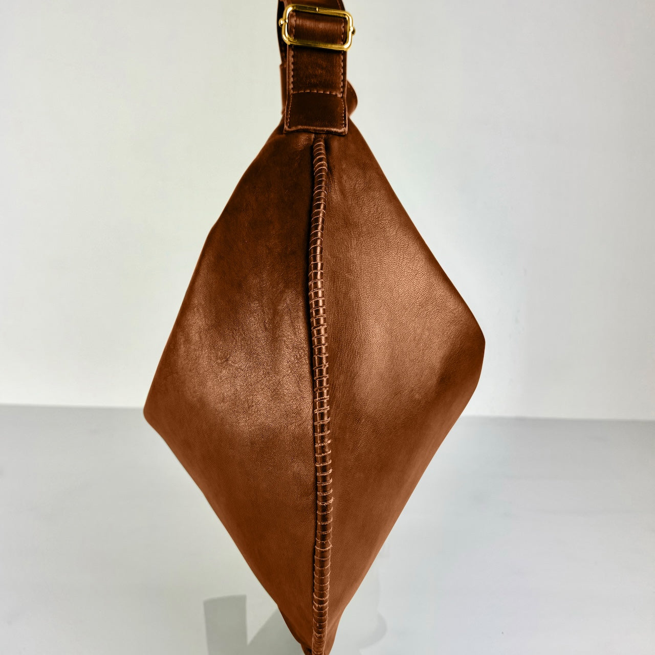 Shoulder Bag Saddle IVY in Caramel Brown: leichte und elegante Schulter- und Umhängetasche von LABEL17. Handgefertigt aus geschmeidigem, pflanzlich gegerbtem Lamm-Nappaleder mit Innenfutter aus Leder und inwendigen Innentaschen und Reissverschluss, tragbar als Handtasche, Schultertasche oder Crossbody.