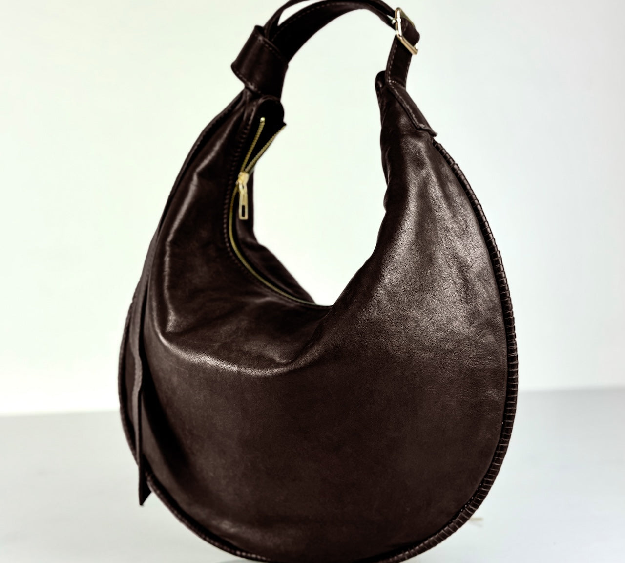 Shoulder Bag Saddle IVY in Darkbrown: leichte und elegante Schulter- und Umhängetasche von LABEL17. Handgefertigt aus geschmeidigem, pflanzlich gegerbtem Lamm-Nappaleder mit Innenfutter aus Leder und inwendigen Innentaschen und Reissverschluss, tragbar als Handtasche, Schultertasche oder Crossbody.