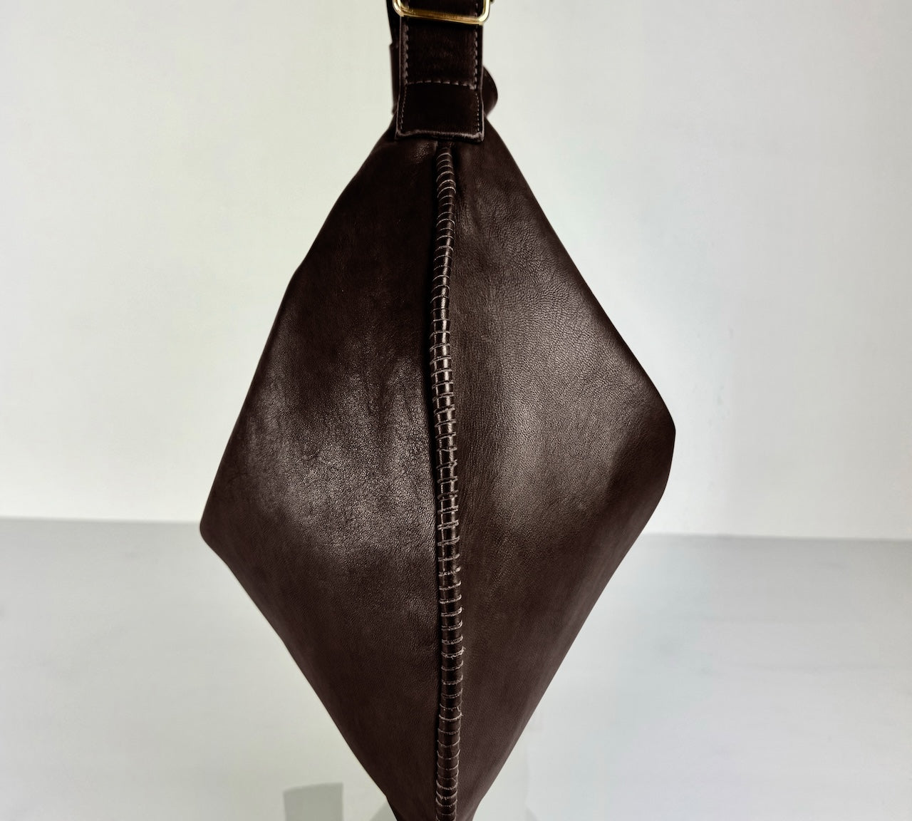 Shoulder Bag Saddle IVY in Darkbrown: leichte und elegante Schulter- und Umhängetasche von LABEL17. Handgefertigt aus geschmeidigem, pflanzlich gegerbtem Lamm-Nappaleder mit Innenfutter aus Leder und inwendigen Innentaschen und Reissverschluss, tragbar als Handtasche, Schultertasche oder Crossbody.