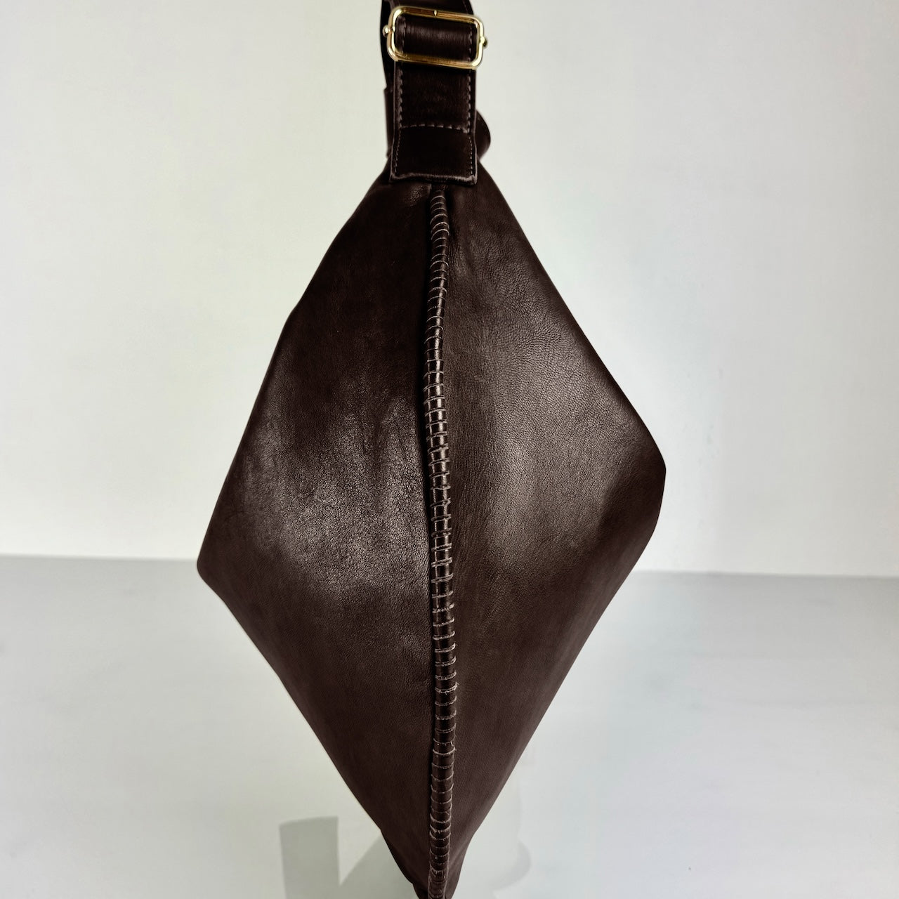 Shoulder Bag Saddle IVY in Darkbrown: leichte und elegante Schulter- und Umhängetasche von LABEL17. Handgefertigt aus geschmeidigem, pflanzlich gegerbtem Lamm-Nappaleder mit Innenfutter aus Leder und inwendigen Innentaschen und Reissverschluss, tragbar als Handtasche, Schultertasche oder Crossbody.